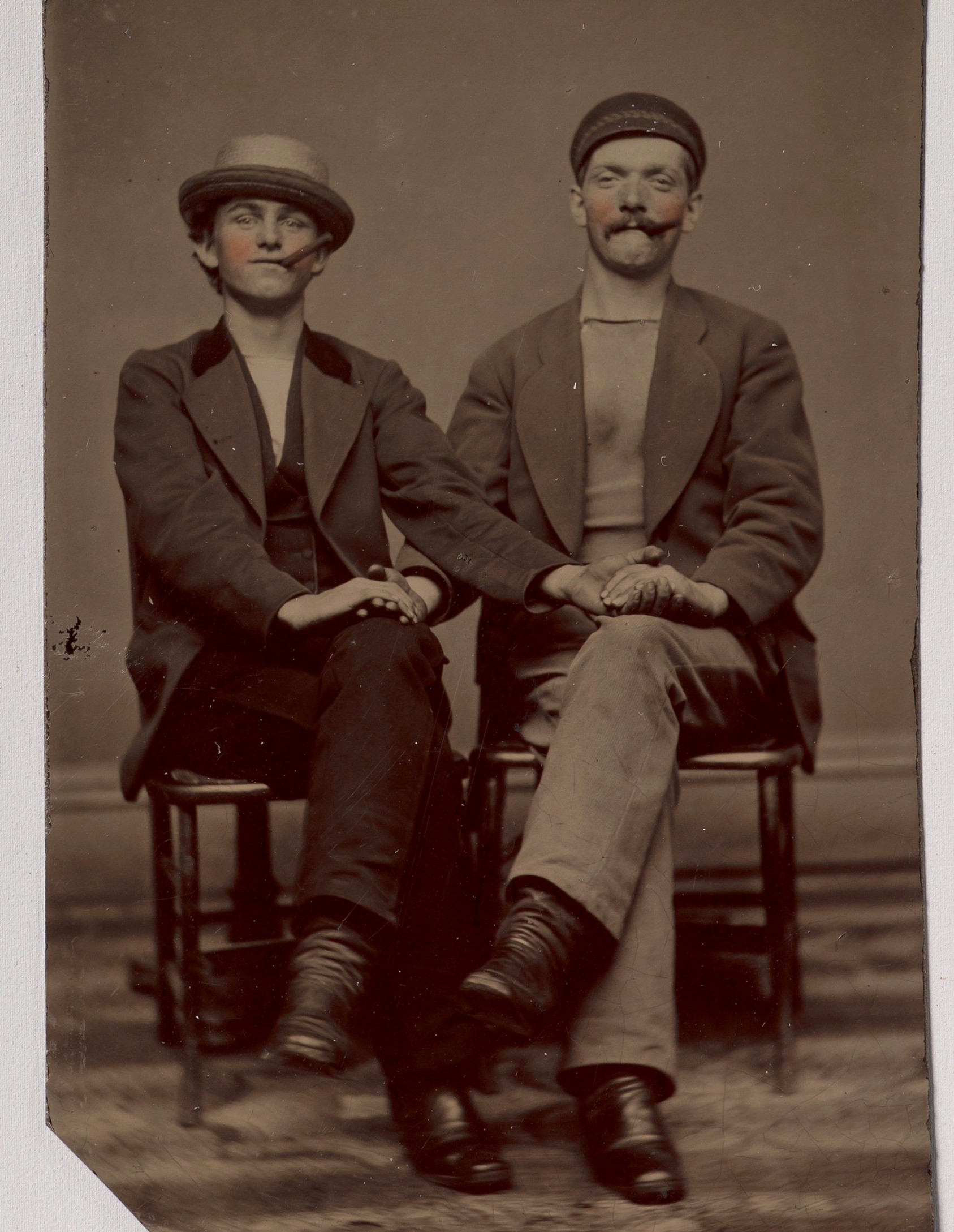 Двое сидящих молодых мужчин, держащихся за руки; тинтайп, фотография неизвестного автора, 1880-е годы