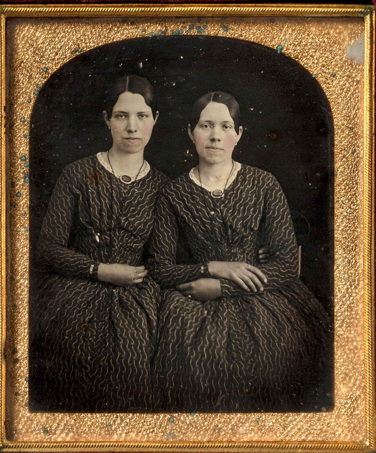 Duas jovens sentadas, vestidas de forma idêntica; daguerreótipo de autor desconhecido, década de 1840