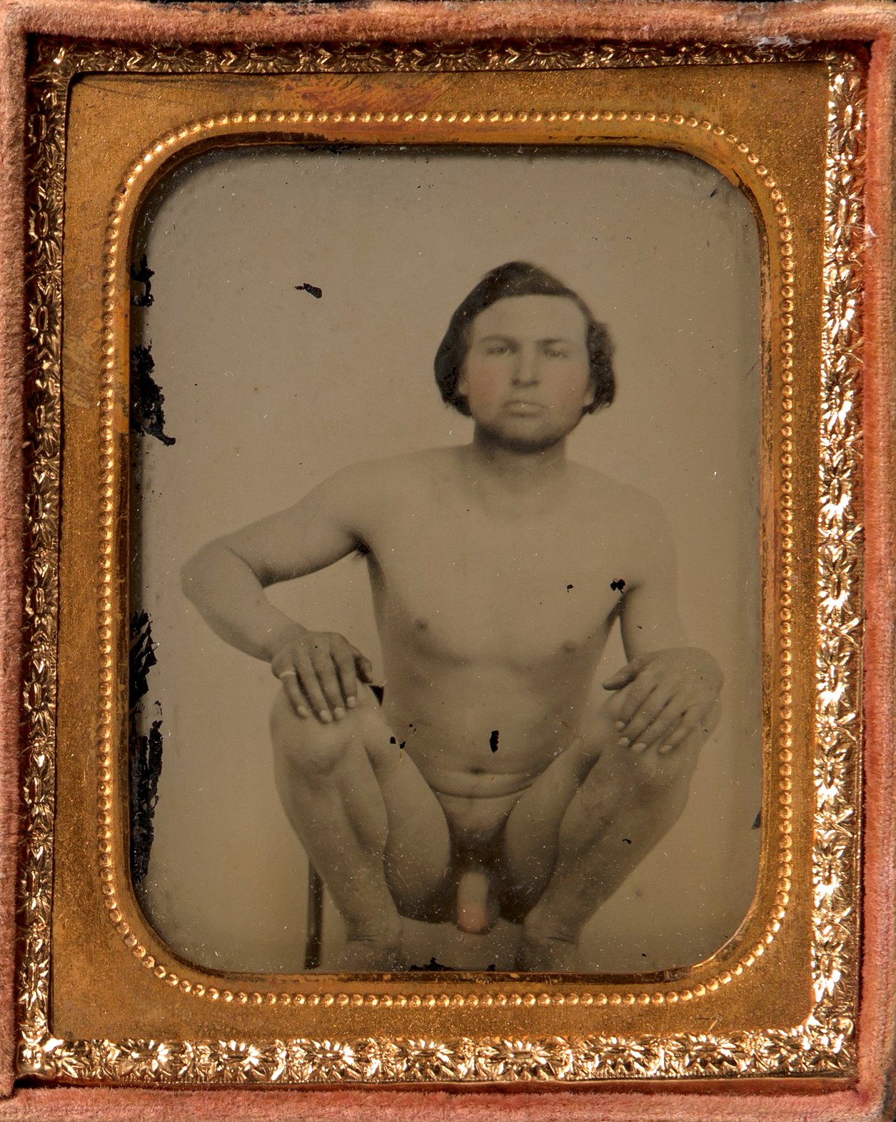 Homem nu agachado sobre uma cadeira; ambrótipo de autor desconhecido, décadas de 1850–1860